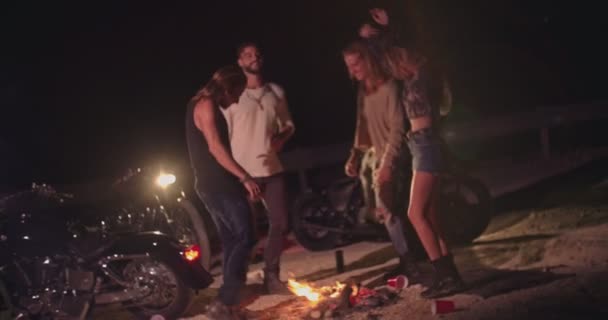 Mladý opilý rebelové přátelé s motocykly tančit kolem táboráku — Stock video