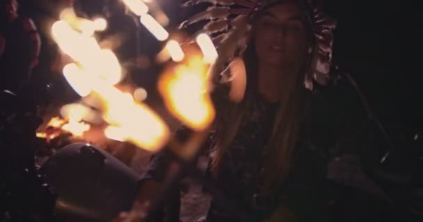 Femme amérindienne avec coiffure en plumes et feux d'artifice la nuit — Video