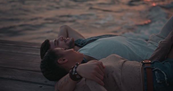 年轻的多民族夫妇在日落时分躺在码头上休息 — 图库视频影像