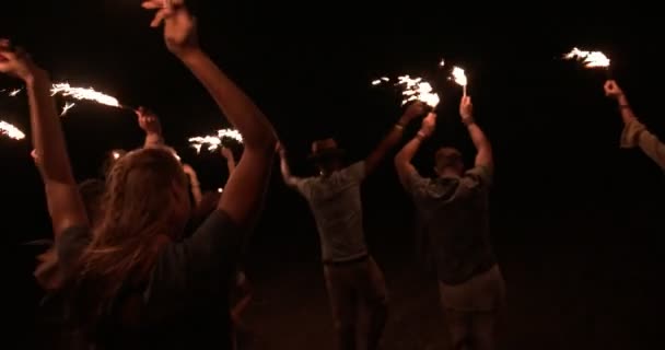 Молодые многонациональные друзья-хипстеры празднуют на открытом воздухе с бенгальскими огнями — стоковое видео