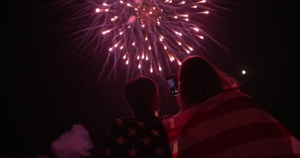 Jóvenes tomando fotos del espectáculo de fuegos artificiales del 4 de julio — Vídeo de stock