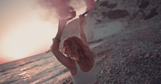 Boho kvinna firar med rökbomber på stranden vid solnedgången — Stockvideo