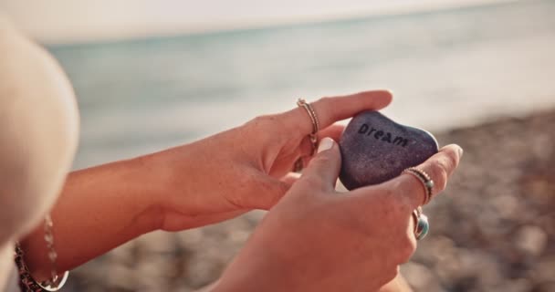 Close-up of boho woman holding pebble at the beach — Stock Video
