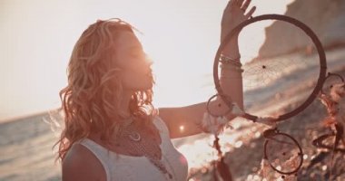 Plajda düş kapanı olan boho tarzı genç bir kadın.