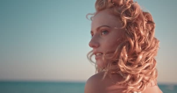 Молода руда хіпі жінка розслабляється на пляжі на заході сонця — стокове відео