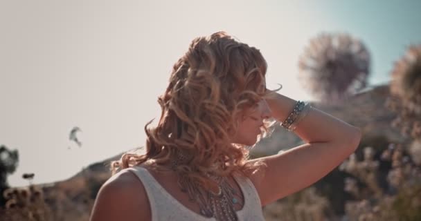Молодая женщина хиппи с серебряными украшениями расслабляется в полевых полевых полевых цветах — стоковое видео