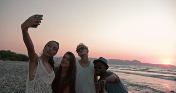 Young multi-ethnic hipster friends taking selfies on beach at sunset — Stock Video