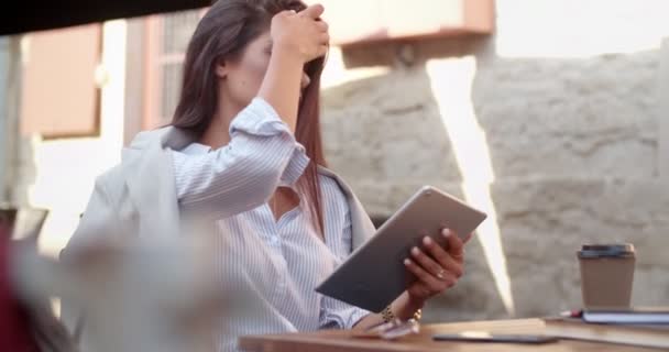 Joven mujer de negocios con estilo utilizando tableta digital en la cafetería — Vídeos de Stock