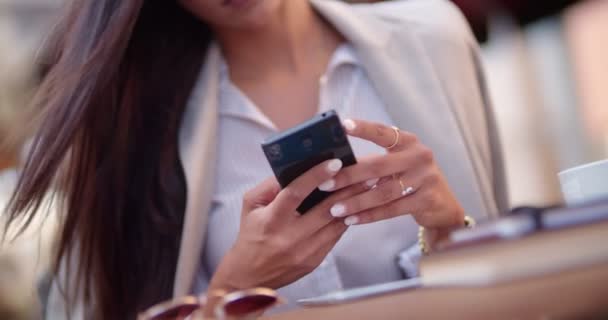 Молода стильна бізнес-леді в кафе смс на смартфон — стокове відео