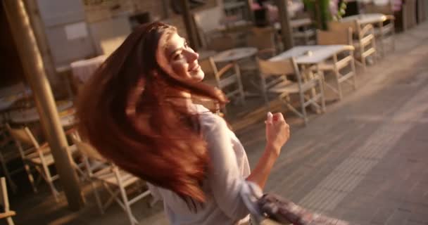 Jong brunette vrouw having plezier spinnen rond in de stad — Stockvideo