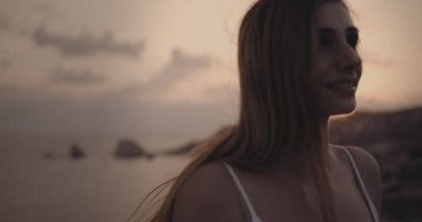 Genç bir kadın yazın deniz kenarında dinleniyor.