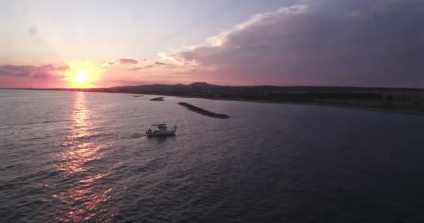 Вид дрона на рибальський човен, що пливе у морських водах острова — стокове відео