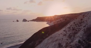 Genç bayan kaşif deniz kıyısındaki dağ yamacında yürüyor.