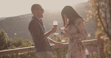 Akdeniz kırsal kesiminin balkonunda kırmızı şarap içen çift