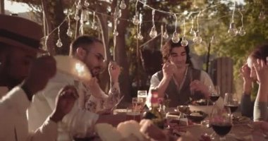 Genç çok ırklı arkadaşlar geleneksel Akdeniz köyü restoranında yemek yiyorlar.