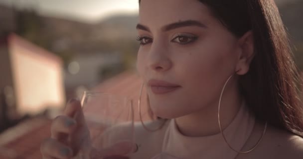 Junge schöne Frau trinkt Rotwein auf der Terrasse des Landhauses — Stockvideo