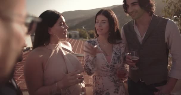 Друзья веселятся и пьют на террасе средиземноморского горного дома — стоковое видео