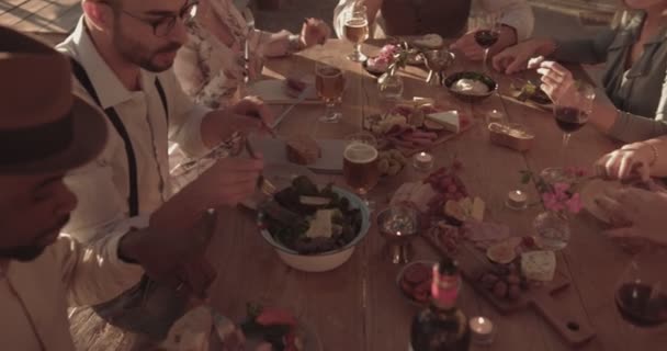 Młodzi, wieloetniczni przyjaciele jedzący śródziemnomorski posiłek w rustykalnej restauracji — Wideo stockowe