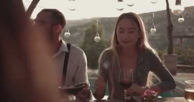 Dağ köyü restoranında Akdeniz yemeği yiyen çok ırklı genç arkadaşlar.