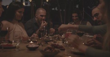 Genç çoklu etnik arkadaşlar ve zarif bir akşam yemeği partisinde kutlama yapan çiftler.