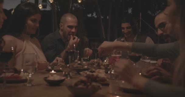 Jeunes amis et couples multi-ethniques célébrant lors d'un dîner élégant — Video