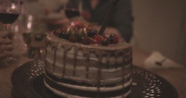 Doğum günü pastası dilimleri kesen bir kadının yakın çekimi.