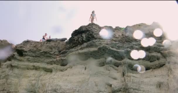 崖から飛び降りて海に飛び込む女 — ストック動画