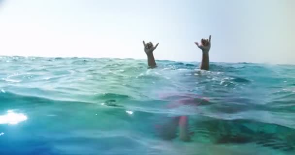 Ember búvárkodás a víz alatt, és csinál rock and roll kéz gesztus — Stock videók