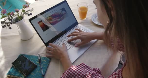 Junge Food-Bloggerin nutzt Laptop und arbeitet online — Stockvideo