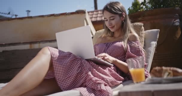 Junge Bloggerin arbeitet am Laptop und entspannt zu Hause — Stockvideo