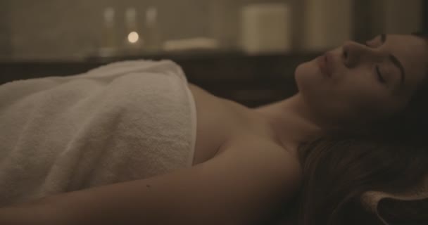 Молодая женщина лежит и расслабляется после процедуры красоты — стоковое видео