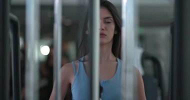 Genç bir kadın spor salonunda spor yapıyor.