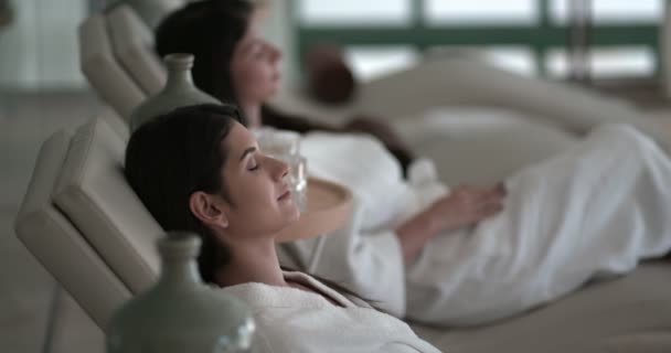 Unga kvinnor som ligger ner och kopplar av på lyxiga spa resort — Stockvideo