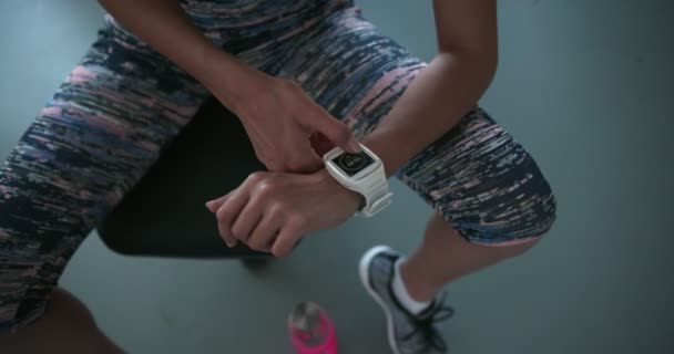 Giovane donna magra utilizzando smartwatch e controllare i progressi di allenamento — Video Stock