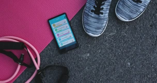 Vue de dessus des accessoires d'entraînement et smartphone avec application fitness — Video