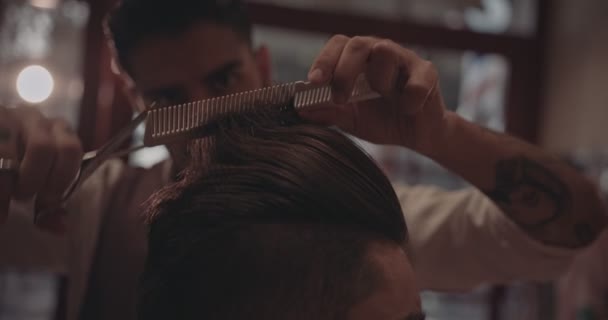 Close-up of barbers hands cutting mans hair in barber shop — Stock Video