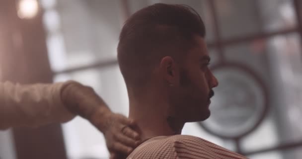 Ung snygg frisör med borste för att rengöra kunden efter frisyr — Stockvideo
