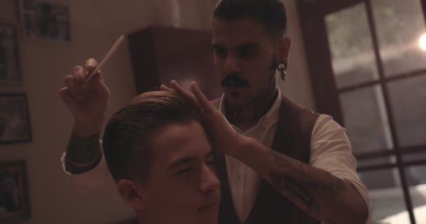 Hipster barber styling teenage boys hair at old-fashioned hair salon — Stock Video