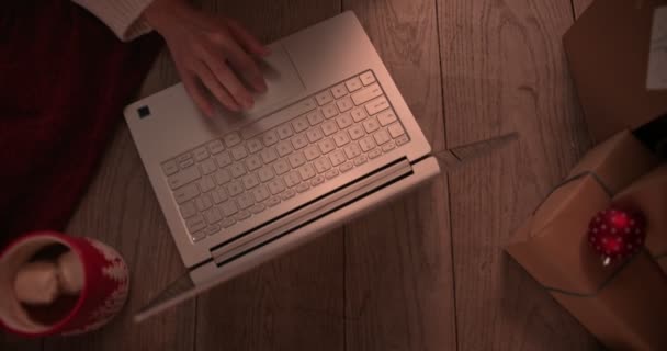Jeune rousse femme shopping en ligne en utilisant un ordinateur portable sous l'arbre de Noël — Video