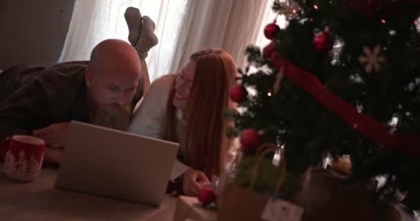 Пара с помощью ноутбука и кредитной карты для покупок на Рождество онлайн — стоковое видео