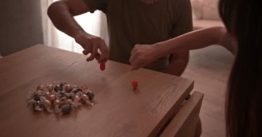 Erkek ve kadın Hanuka 'da evde dreidel oyunu oynuyorlar.
