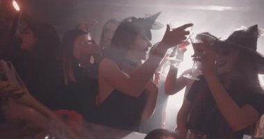 Cadılar Bayramı kostümlü gençler barda içkiyle kadeh kaldırıyorlar.