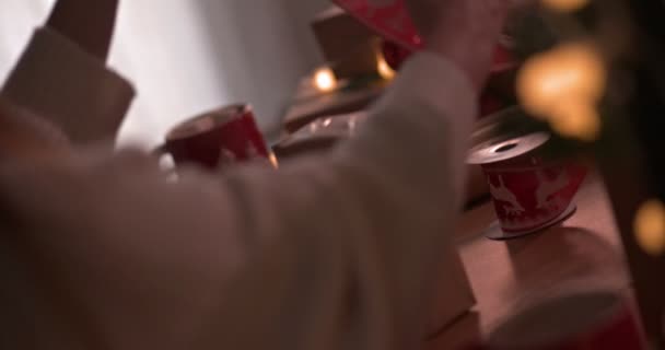 Пара обгортає різдвяні подарунки разом зі стрічкою — стокове відео