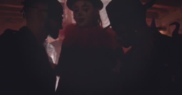Наряженная женщина танцует и флиртует с мужчинами на вечеринке Хэллоуина — стоковое видео