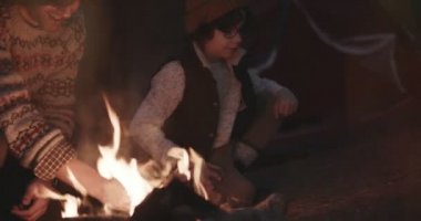 Baba oğul kamp ateşi yakıyor ve dağda kamp yapıyorlar.