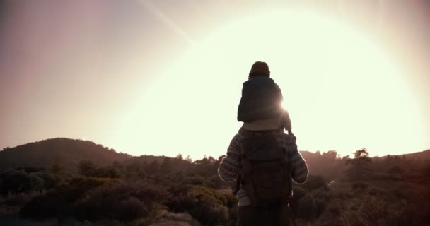 肩に息子を担いで山道をハイキングする父 — ストック動画