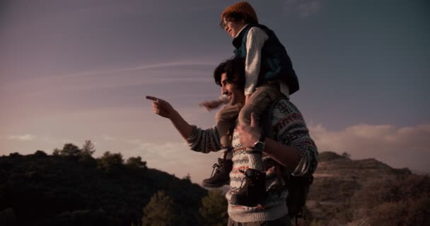 Отец и сын в походе в горы приключения глядя на вид — стоковое видео