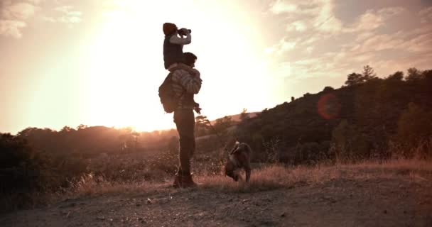 Baba ve oğul aile köpeğiyle yürüyüş yapıyor ve dürbün kullanıyor. — Stok video