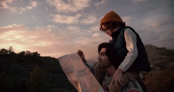 Joven padre e hijo excursionistas leyendo mapa en las montañas — Vídeo de stock