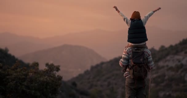 Vader en zoon wandelaars op bergtop kijkend naar uitzicht — Stockvideo